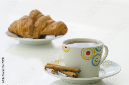 Fototapeta Naklejka Na Ścianę i Meble -  Tea in white mug with cinnamon and croissant