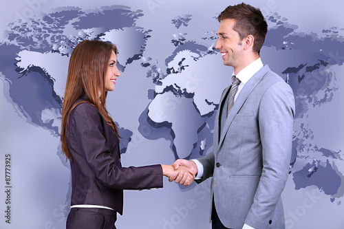Фотография Business colleagues shaking hands on world map background