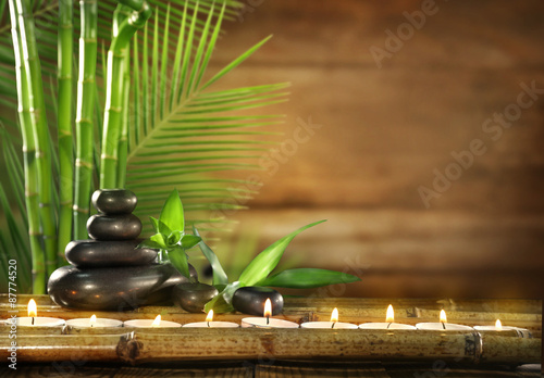 Spa stones, candles on wooden background