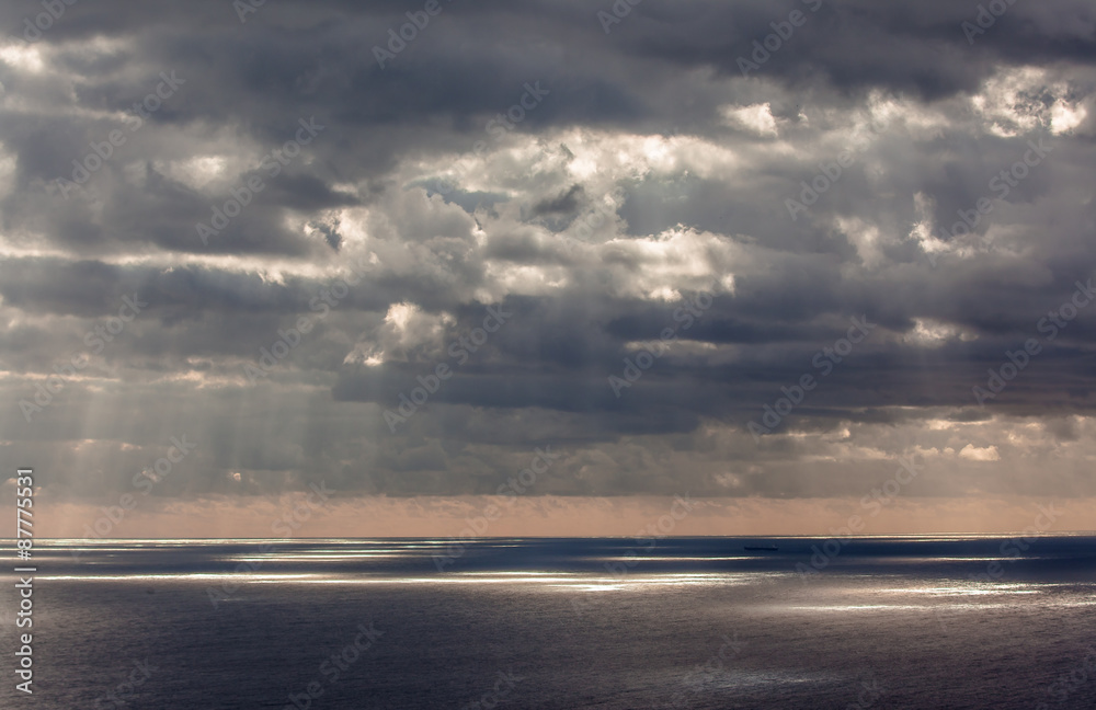 rayons lumineux à travers nuage noir au-dessus de la mer 