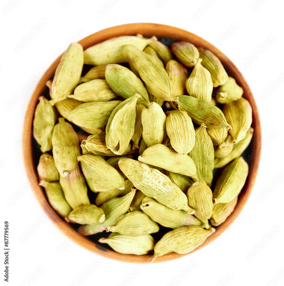 Cardamom in wooden bowl, isolated on white Cardamom in wooden bowl, isolated on white