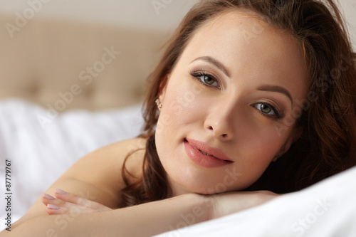 Portrait of pretty relaxed woman posing in bedroom