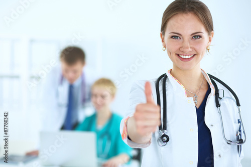 Female doctor shows a sign okay standing in hospital photo