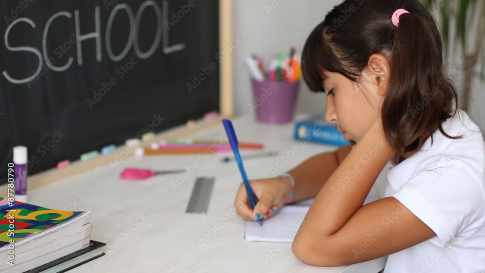 Schoolgirl writes and smiles to the camera Schoolgirl writes and smiles to the camera