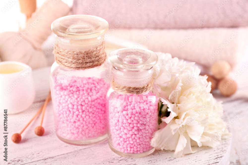Glass bottles with color spa sea salt on wooden table, closeup Glass bottles with color spa sea salt on wooden table, closeup