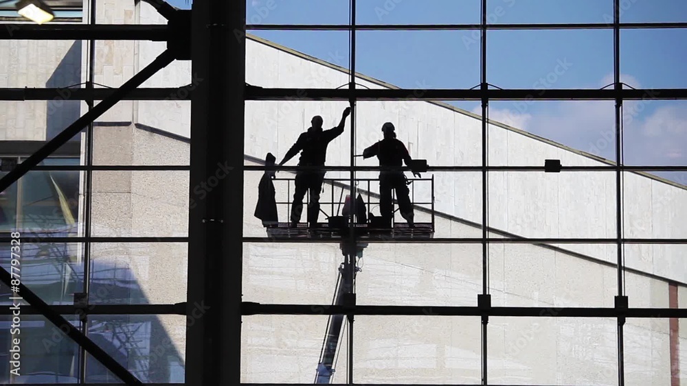 Two unrecognized washers washing windows.Industrial Climbers, facade cleaning