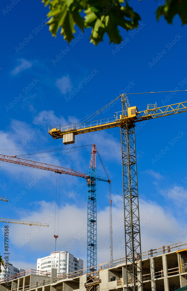 Crane and building construction against blue cloudy sky