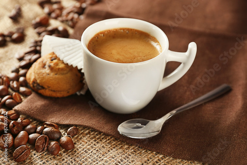 Cup of coffee with cookie on table, closeup