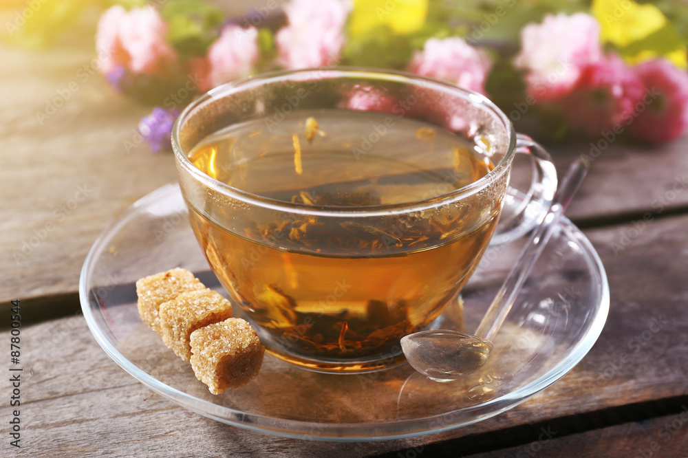 Cup of herbal tea with flowers on wooden table, closeup Cup of herbal tea with flowers on wooden table, closeup