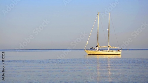 A sailboat on the horizon in the beautiful Caribbean ocean sunrise LOOP photo