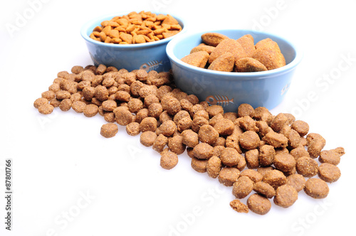 Blue ceramic dogs bowls. Dry dog food in bowl isolated on white background. Dry dog food isolated on white background