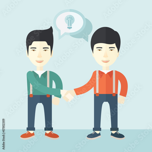 Two asian guys happily handshaking.