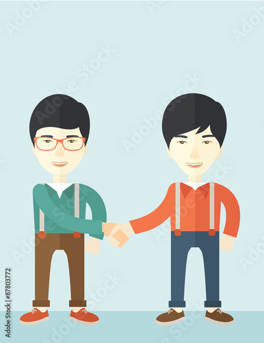 Two asian guys happily handshaking.