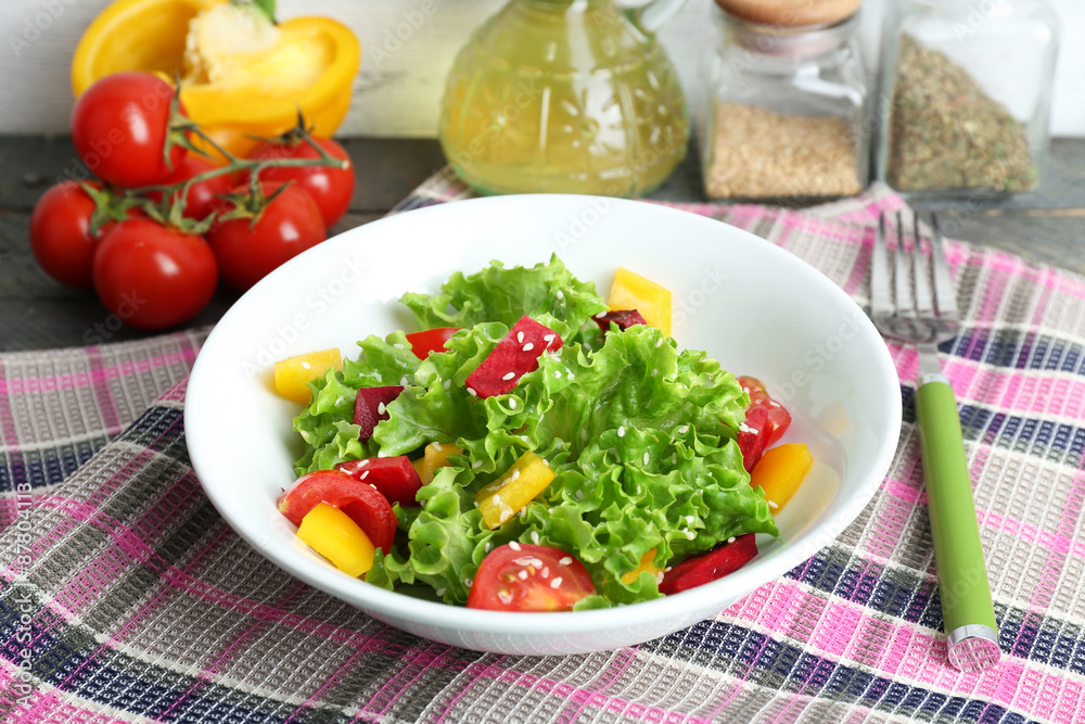 Bowl of fresh green salad on table with napkin, closeup Bowl of fresh green salad on table with napkin, closeup