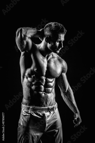 very muscular handsome athletic man on black background © Andriy Petrenko