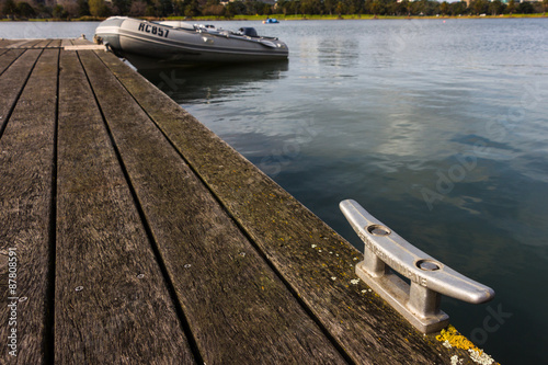 Mooring Bollard with Rubber Dinghy in the Background photo