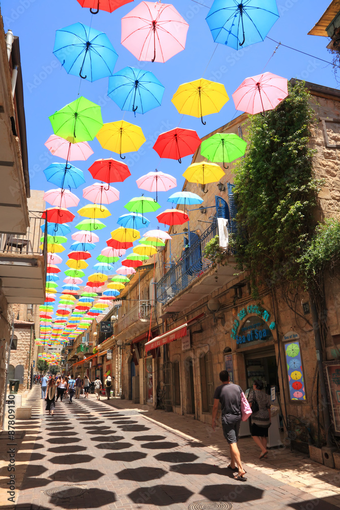 JERUSALEM,ISRAEL - JULY 19,2015:Colorful umbrellas floating magically in  the sunny blue sky above pedestrian Yoel Moshe Salomon Street with  galleries, ceramics, arts jewelry and clothing shops Stock Photo | Adobe  Stock