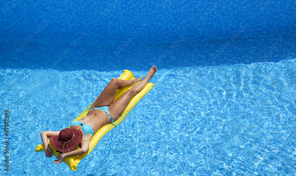 Frau im Swimmingpool auf Luftmatratze