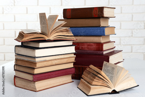 Heap of old books on brick wall background