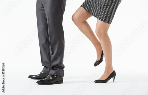 Businesswoman kicking a businessman