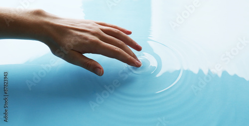 Finger touches water close up photo