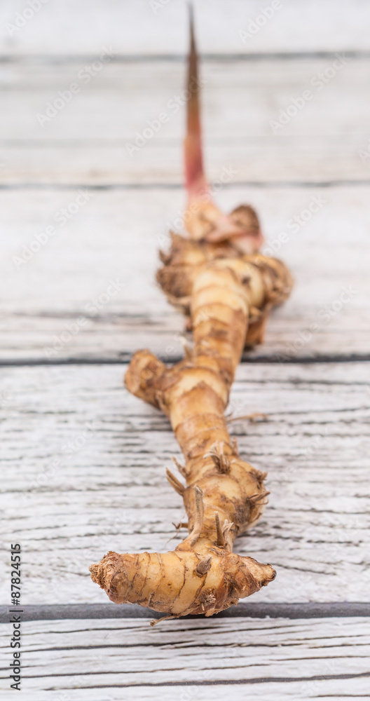 Galangal or Lengkuas roots over wooden background