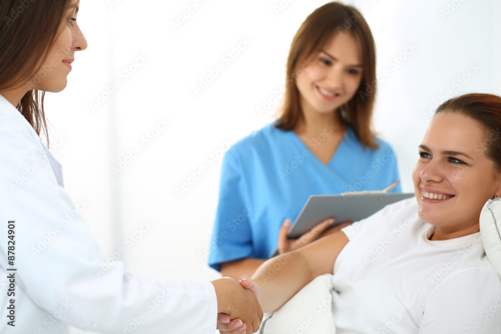 Female doctor shaking hands with patient Female doctor shaking hands with patient