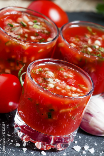 Tomato juice with vegetables and fresh tomato on dark stone back