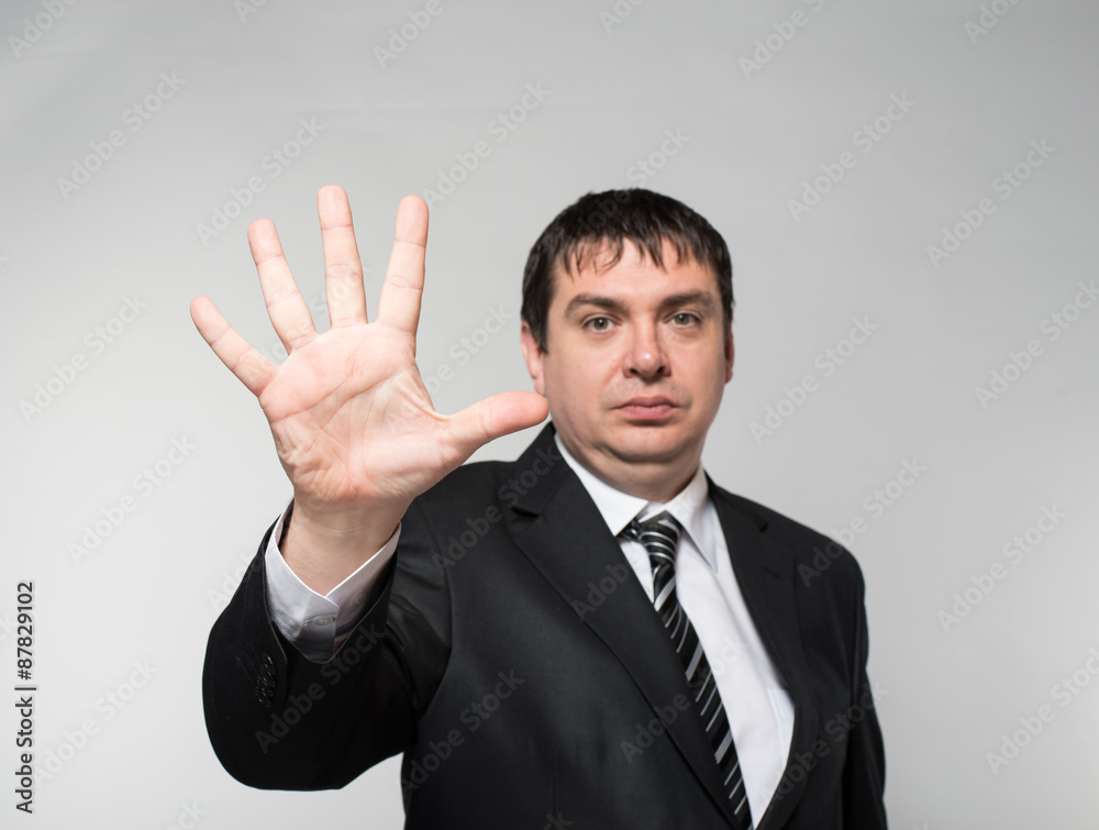 Happy businessman showing five fingers on a gray background Happy businessman showing five fingers on a gray background