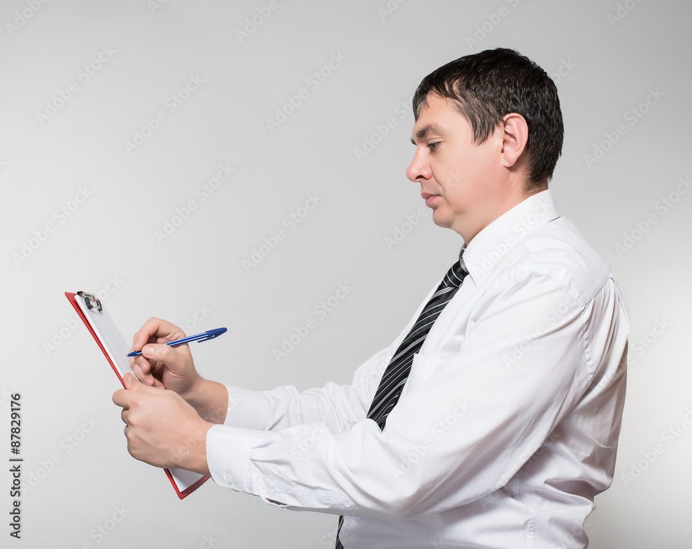 portrait of a young businessman making notes in documents