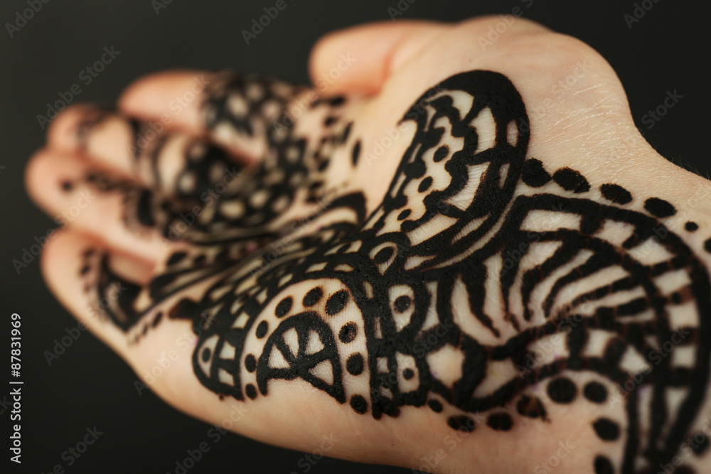 Closeup image of henna on female hand on dark background Closeup image of henna on female hand on dark background