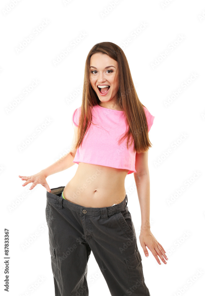 Young slim woman wearing too big pats isolated on white Young slim woman wearing too big pats isolated on white
