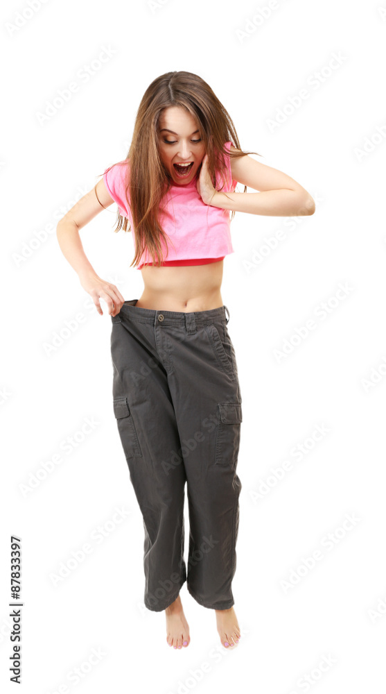 Young slim woman wearing too big pats isolated on white Young slim woman wearing too big pats isolated on white