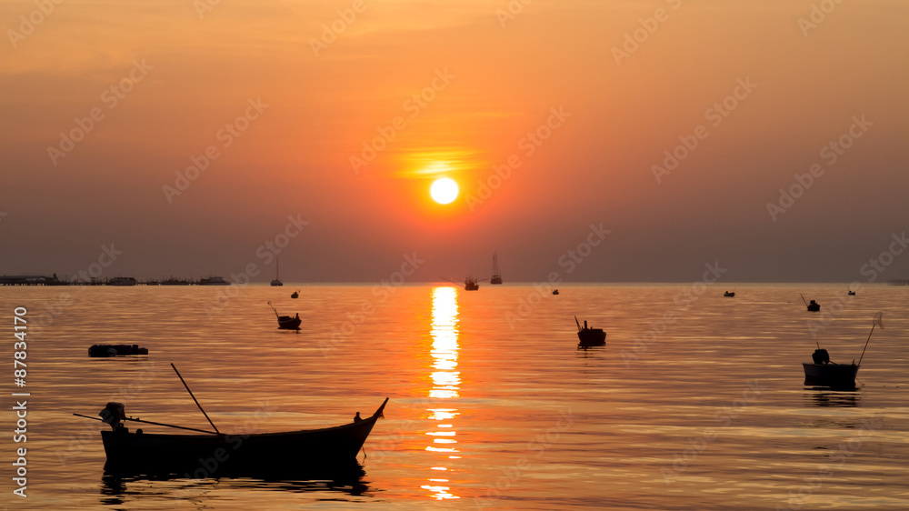 Silhouette of Small Ships in The Sea at Twilight Time with Beautiful Sun and Reflection