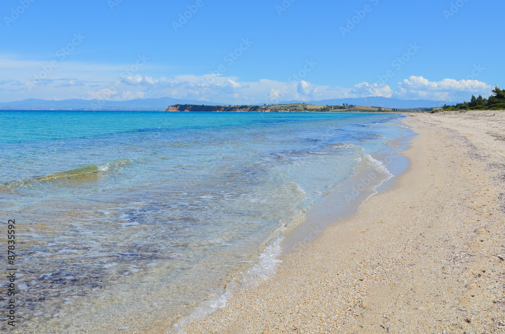 Panoramic view of a long white sand beach beside the turquoise s