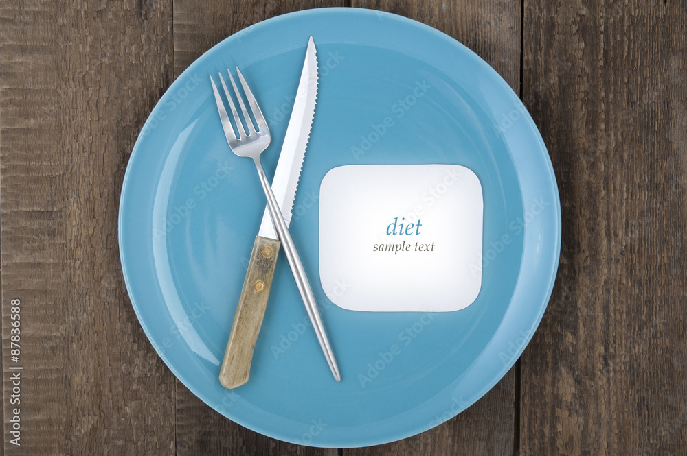 Empty plate with fork and knife on wood background.. Empty plate with fork and knife on wood background..