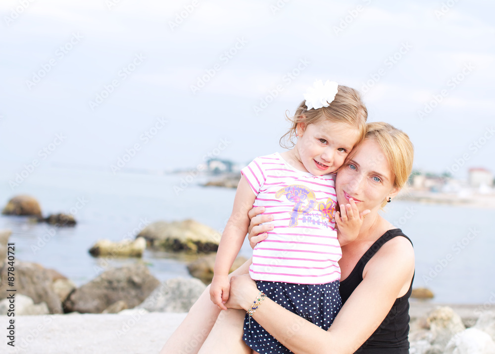 Happy mother and daughter on the beach 