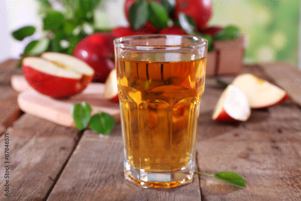 Glass of apple juice with red apples on wooden table, closeup Glass of apple juice with red apples on wooden table, closeup