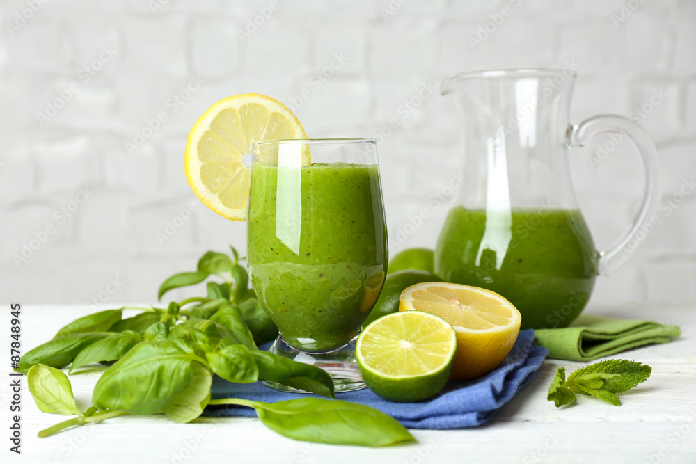 Fototapeta premium Healthy green smoothie on wooden table on white wall background