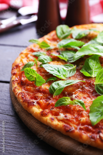 Pizza with basil on wooden table  closeup