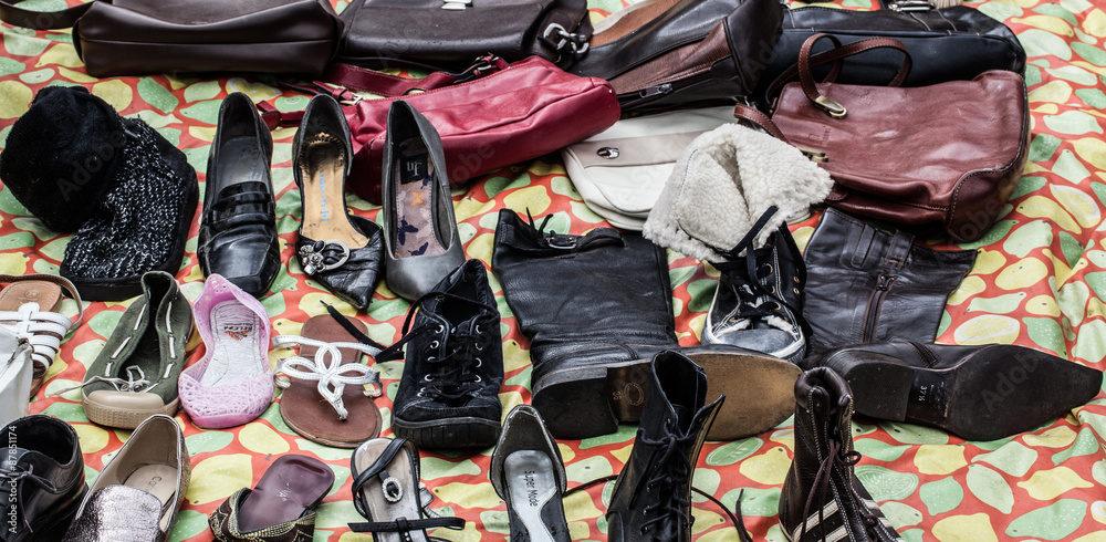 mix of second hand leather shoes, boots,purses and bags on sale at garage  sale for donation, recycling or selling for cheap to cope with  over-consumption Stock-Foto | Adobe Stock