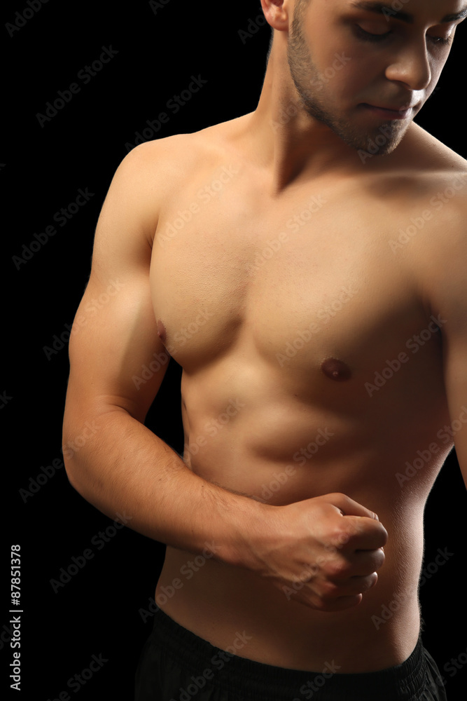Fototapeta premium Muscle young man on dark background