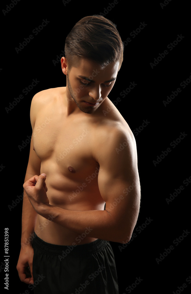 Fototapeta premium Muscle young man on dark background