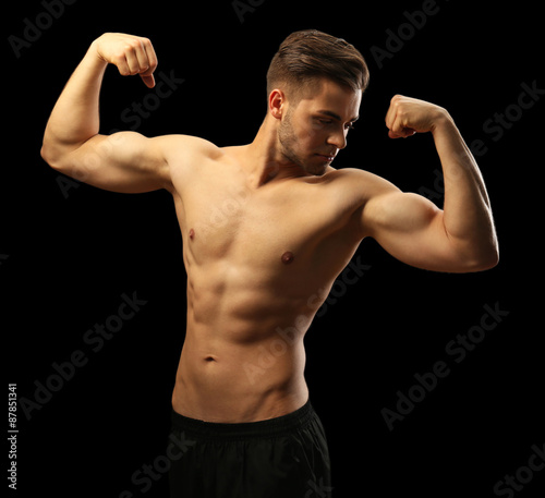 Muscle young man on dark background