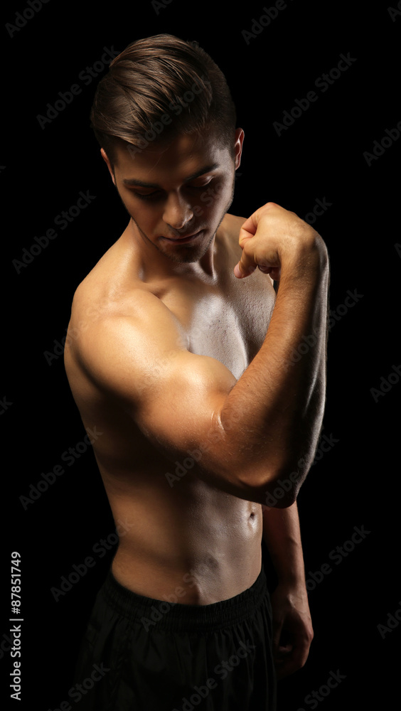 Fototapeta premium Muscle young man on dark background