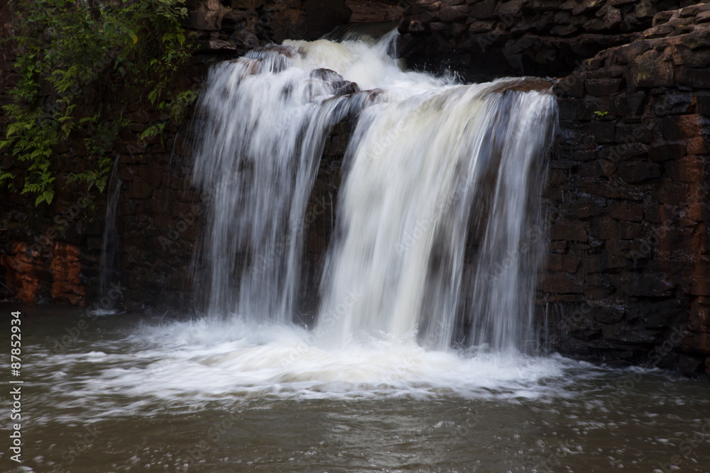 Fototapeta premium Mountain water cascading by rocks