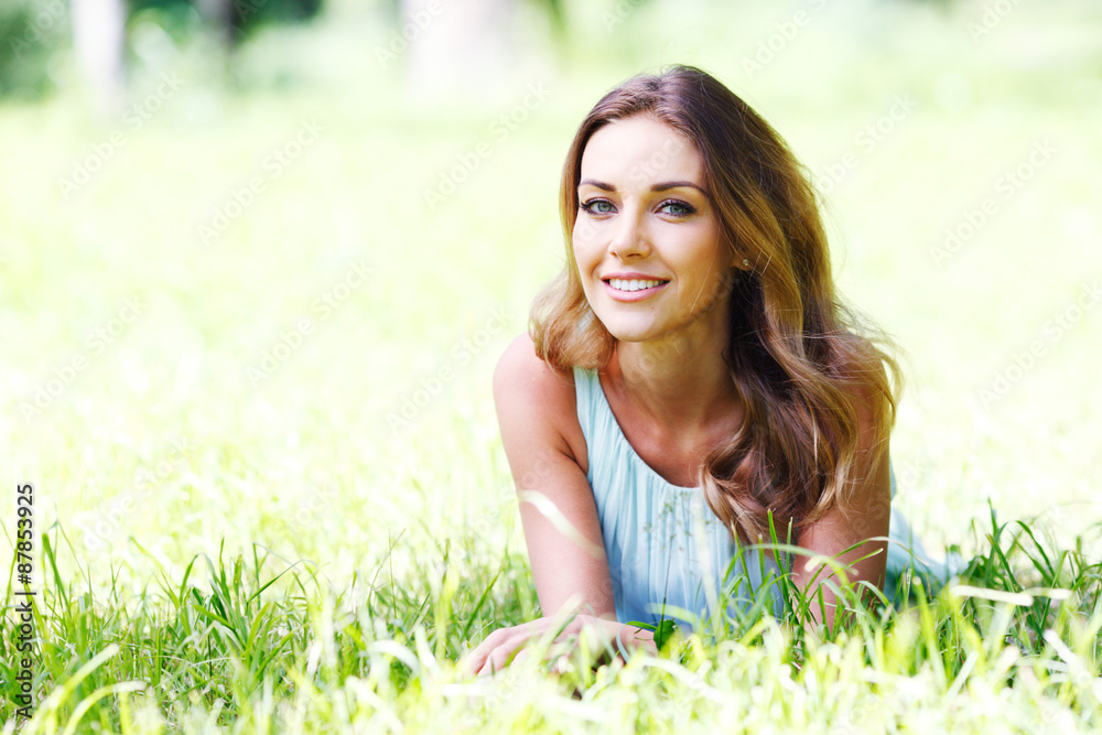 young woman in blue dress lying on grass young woman in blue dress lying on grass