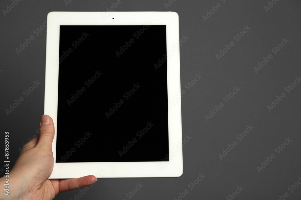 Hand holding tablet on gray background Hand holding tablet on gray background