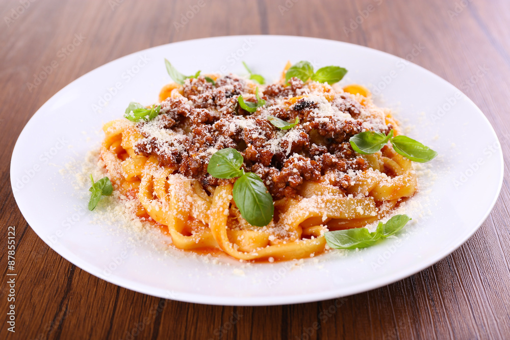 Pasta Bolognese with parmesan and basil on table close up Pasta Bolognese with parmesan and basil on table close up
