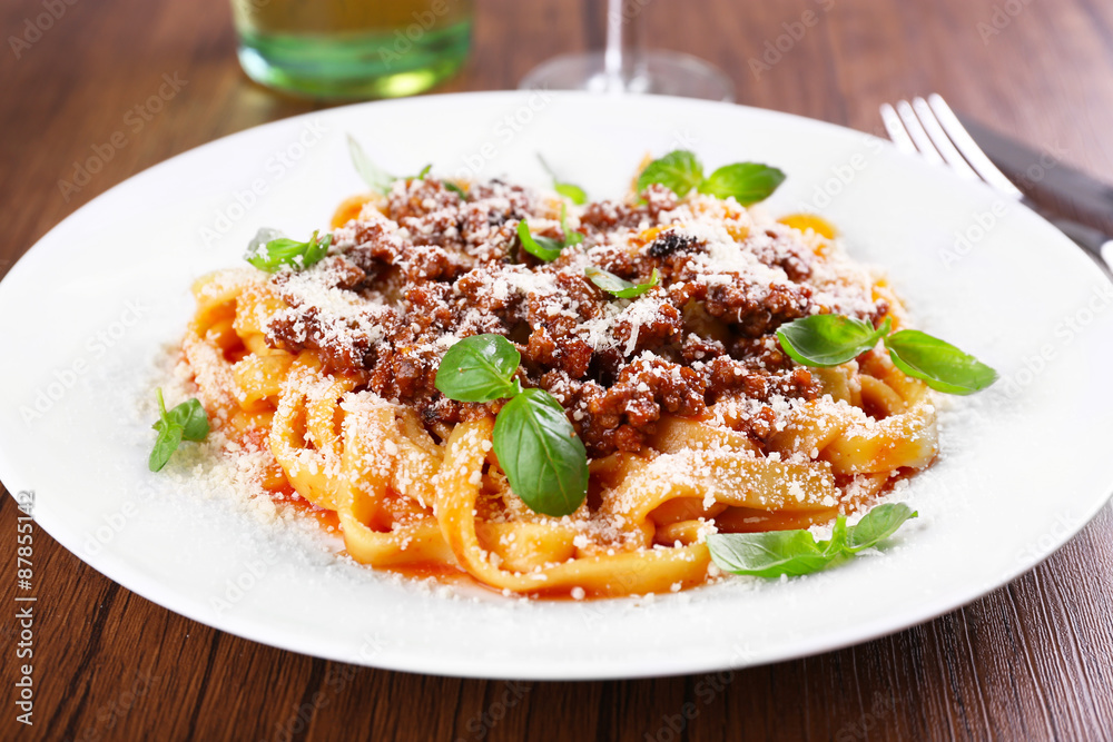 Pasta Bolognese with parmesan and basil on table close up Pasta Bolognese with parmesan and basil on table close up